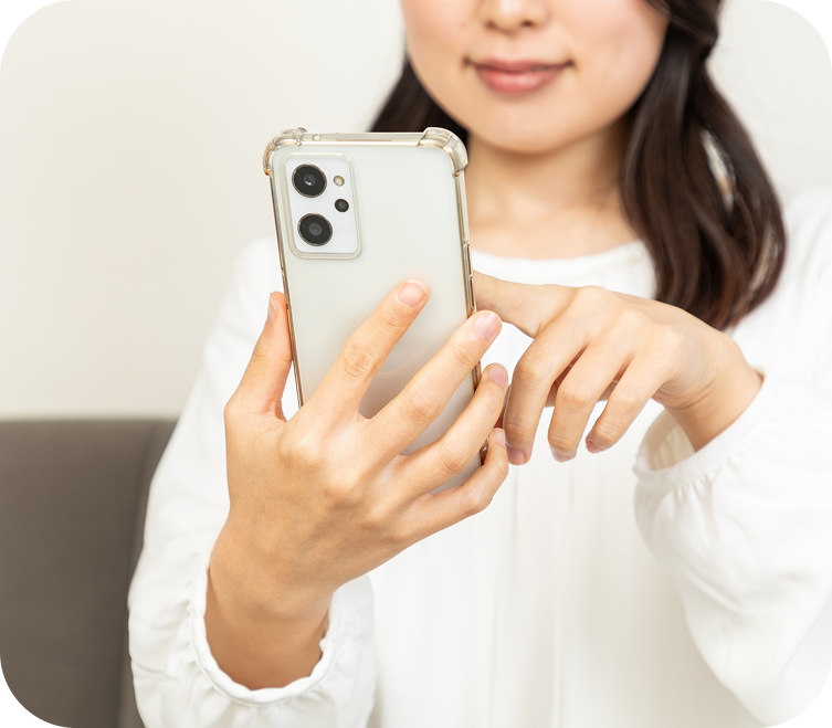 スマートフォンで問い合わせする女性の手元